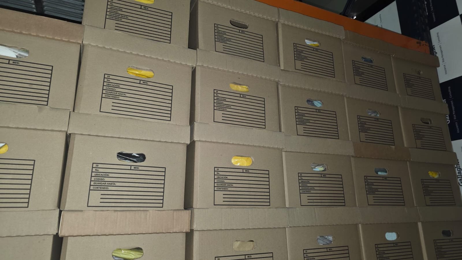 Cajas de archivo rotuladas y apiladas con orden en estantería, después de la intervención de SOS Archivos